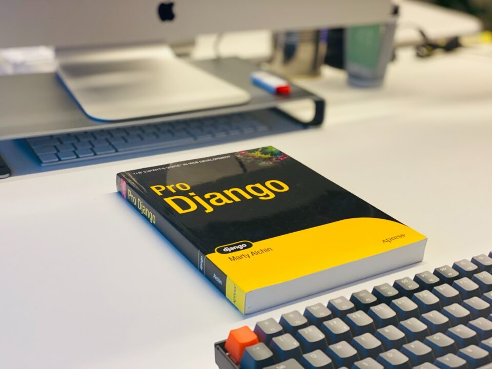 Black and yellow Django book in front of computer